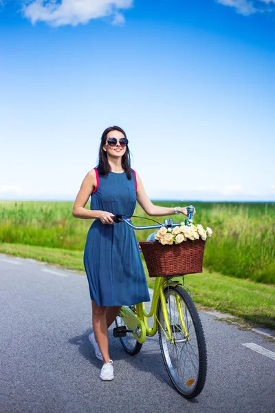 Glückliche Frau im Kleid posiert mit Vintage Fahrrad mit Korb — Stockfoto