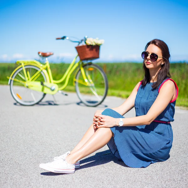 Glückliche Frau sitzt auf der Straße mit Retro-Fahrrad — Stockfoto