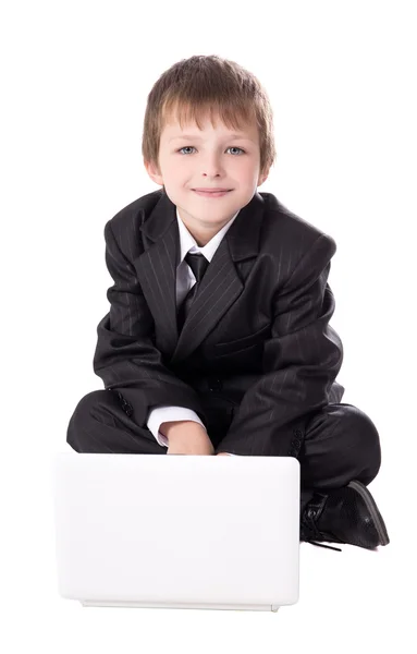 Menino bonitinho no terno de negócios com laptop isolado no branco — Fotografia de Stock