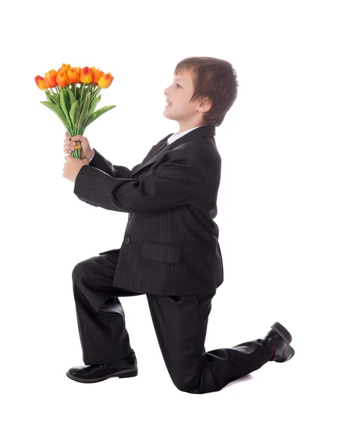 Kleiner Junge in der Wirtschaft zu entsprechen gebende Blumen an jemanden isoliert — Stockfoto