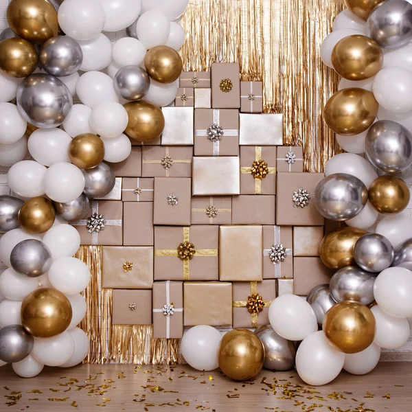 Christmas, new year or birthday background - wall decoration in golden and silver color with gifts and air balloons
