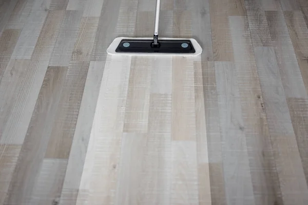 housekeeping and hygiene concept - top view of modern mop cleaning wooden floor at home