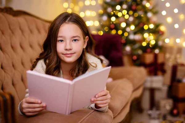 Karácsonyi Koncepció Gyönyörű Kislány Olvasókönyv Díszített Nappaliban Karácsonyfa Fények — Stock Fotó