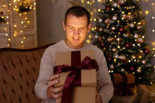 크리스마스와 크리스마스 트리와 휴일등으로 어두운 방에서 상자를 청년의 — 스톡 사진