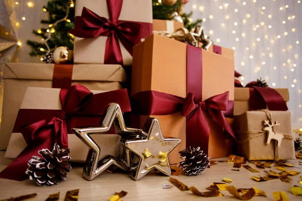 装飾されたクリスマスツリーの近くの星とギフトを包んだ — ストック写真