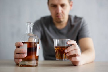 Alkolizm, sorunlar ve depresyon kavramı - erkek ellerinde cam ve viski şişesine yakın çekim