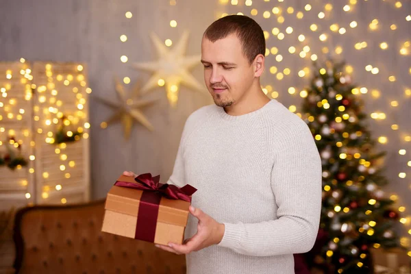 크리스마스와 크리스마스 트리가 거실에 상자를 잘생긴 남자의 초상화 — 스톡 사진