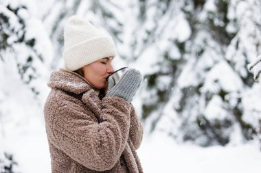 Ormanda sıcak çay içen güzel bir kadının portresi.