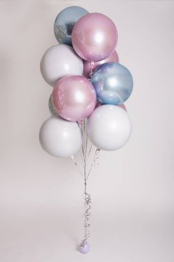 Gri zemin üzerinde renkli pastel helyum hava balonları