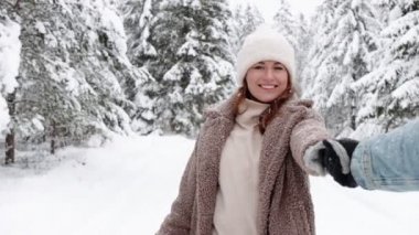 Beni takip edin. Sevgilisiyle birlikte kış ormanında yürüyen mutlu tatlı kız.