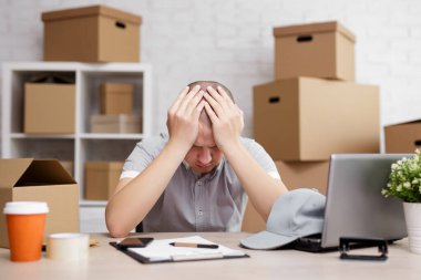 İş, iş, iflas ve depresyon kavramı. Arkasında kutularla postanede üzgün ya da yorgun postacı.