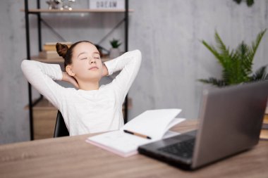 Okul, ev ödevi ve uzaktan eğitim kavramı. Ev ödevlerini yaptıktan sonra dinlenen tatlı bir kız.