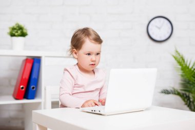 çocukluk, eğitim ve teknoloji konsepti - evde ya da sınıfta dizüstü bilgisayar kullanan küçük tatlı bir kızın portresi