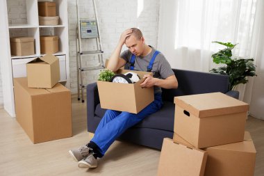 Sıkı çalışma konsepti: Odadaki kanepede oturan üniformalı yorgun yükleyicinin portresi.