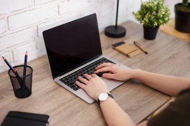 Bilgisayarın ve ellerin ahşap masanın üzerine yakın plan.