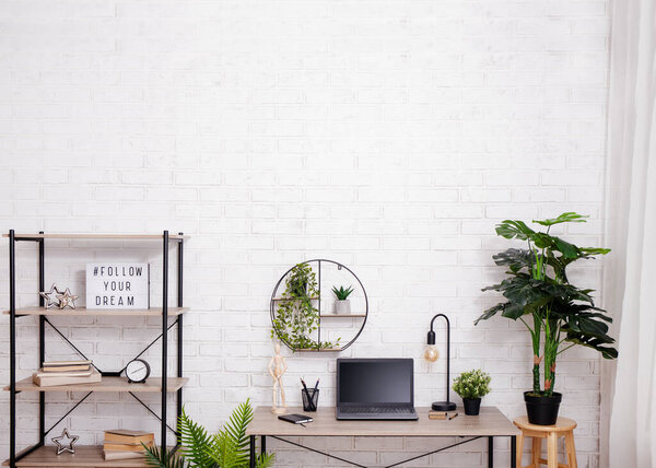 Workspace with table, chair, rack and plants - copy space on wall
