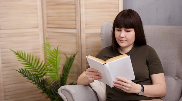 Μελαχρινή Γυναίκα Διαβάζει Ενδιαφέρον Βιβλίο Στο Σαλόνι — Φωτογραφία Αρχείου