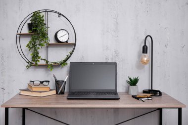 Bilgisayarı beton duvar arkaplanının üstünde olan işyeri