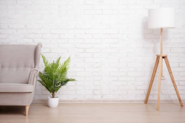 Kanepe, lamba ve bitki, tuğla duvar arkaplanının üzerinde kopyalama alanı