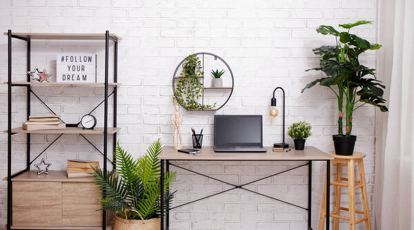 Workspace with table, chair, rack and plants in office or home