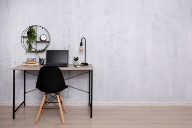 Ofiste dizüstü bilgisayarı olan ya da gri duvarda evi olan işyeri