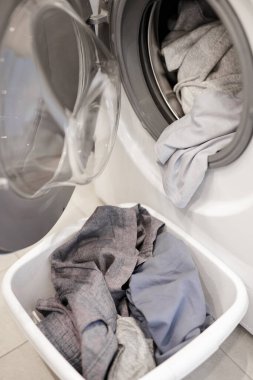 Ev işi kavramı - modern çamaşır makinesinin kapanışı ve banyoda çamaşır.