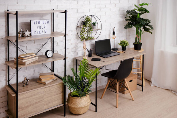 Workplace with laptop on the table in office or home