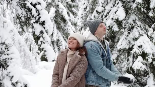 快乐的年轻夫妇在冬天的森林里扔雪 动作缓慢 — 图库视频影像