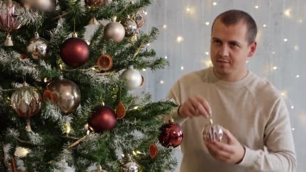 Jovem Homem Bonito Decoração Árvore Natal Com Bugigangas Coloridas — Vídeo de Stock