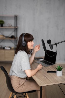 İnternet, yaratıcılık, podcast, blog ve sosyal medya konsepti - ev stüdyosunda ses podcast 'i kaydeden genç kadın