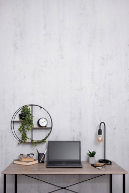 Ofiste ya da evde dizüstü bilgisayarı olan işyeri - beton duvar arkaplanı üzerine kopyalama alanı