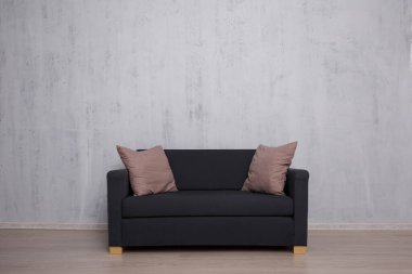 Beton duvar arkaplanının üzerinde kopya alanı olan modern kanepe