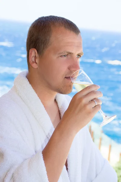 Happy man in bathrobe drinking champagne on balcony — Stok Foto