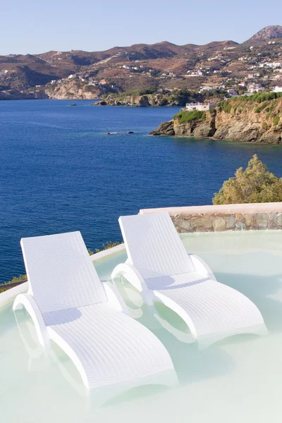 White chairs in pool with sea view — Stock Photo, Image