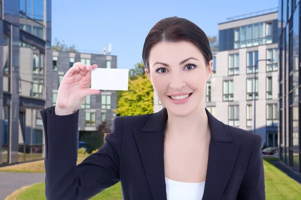 Tarjeta de visita negocios hermosa mujer mostrando en la calle contra — Foto de Stock