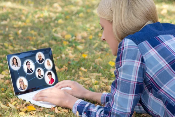 Concepto de red social - mujer usando laptop con retratos de personas —  Fotos de Stock