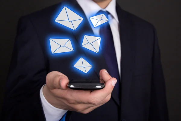 Smartphone im Geschäft man Hand und fliegende Umschläge — Stockfoto