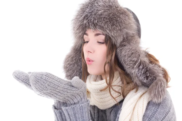 Žena v zimní oblečení něco z její dlaně foukání izolace — Stock fotografie
