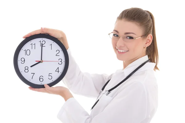 Happy young female doctor with office clock isolated on white — Stock Photo, Image