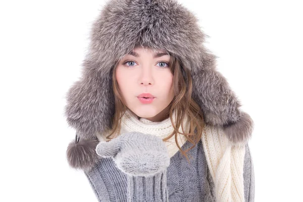 Young woman in winter clothes blowing something from her palms i — Stock Photo, Image