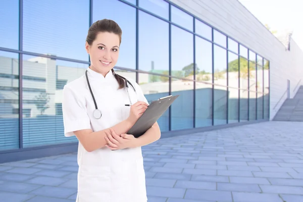 Medico femminile in piedi contro la costruzione dell'ospedale moderno — Foto Stock