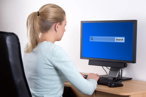 Mulher procurando algo na internet com o computador pessoal em — Fotografia de Stock