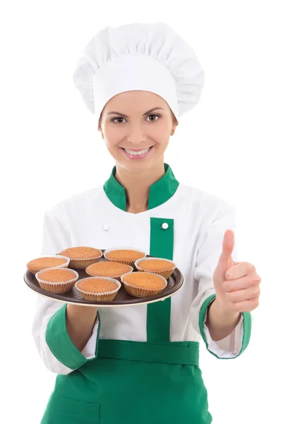 Young chef woman in uniform holding tray with muffins and thumbs — Stock Photo, Image