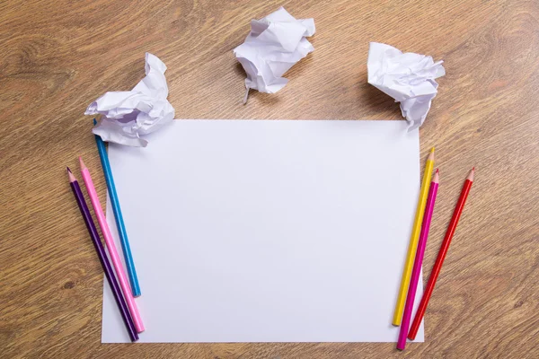 Bunte Bleistifte auf klare weißem Papier mit bröckeln Papier Kugeln o — Stockfoto