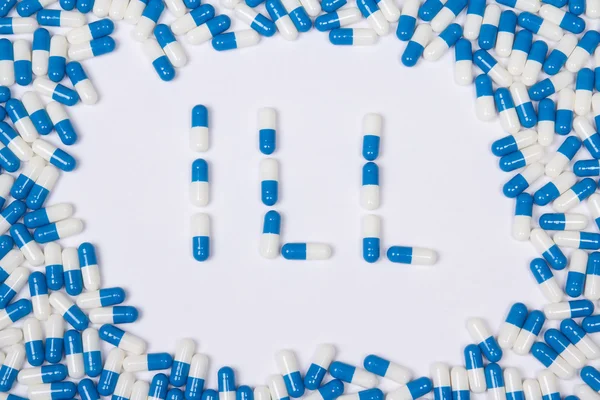 Ill word text made of blue tablets, pills and capsules — Stock Photo, Image