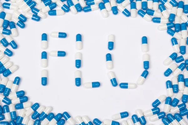 Flu word text made of blue tablets, pills and capsules — Stock Photo, Image