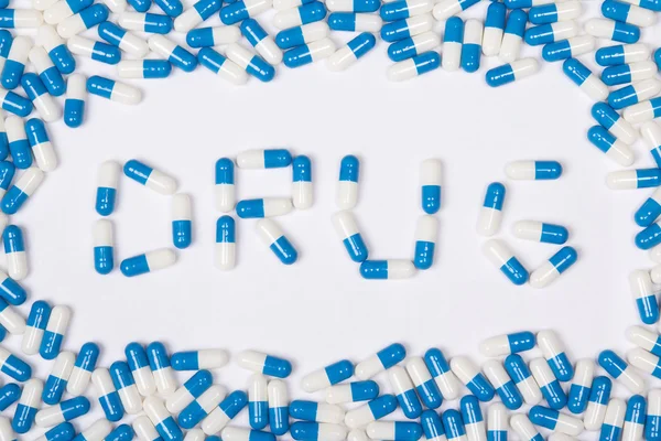Текст слова наркотиков изготовлены из синей таблеток, пилюль и капсул — стоковое фото