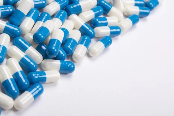 Curar de pílulas azuis no fundo branco — Fotografia de Stock