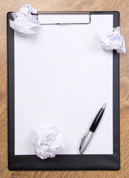 Caneta no papel de clara branco com crumble de bolas de papel na tabl de madeira — Fotografia de Stock