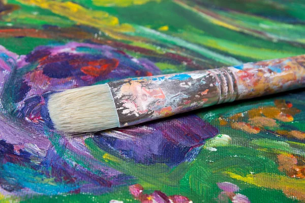 Escova de pintura sobre fundo de lona colorida — Fotografia de Stock